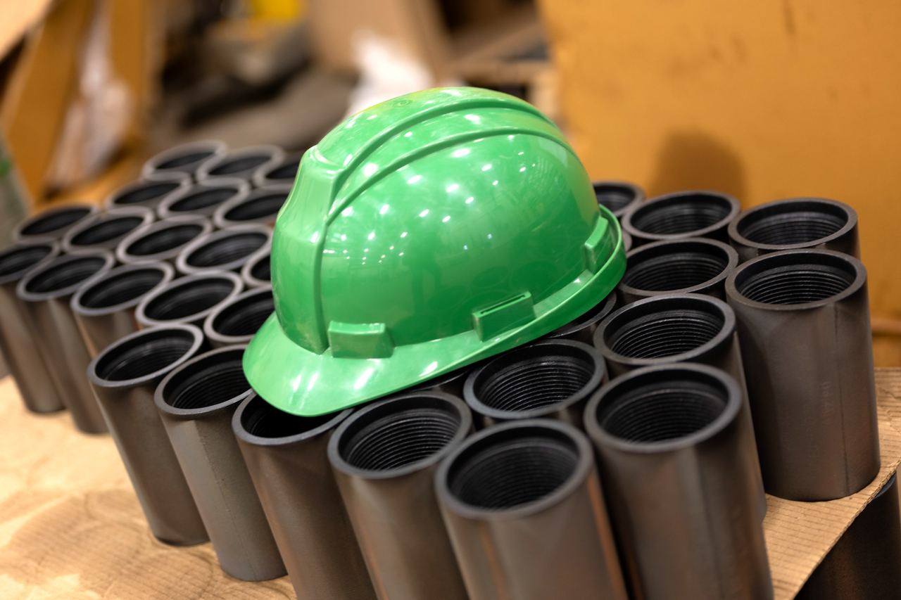 Green hardhat on pipes