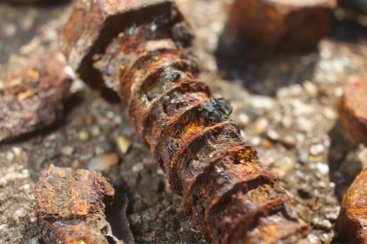 A close-up shot of an industrial screw that has been severely corroded.