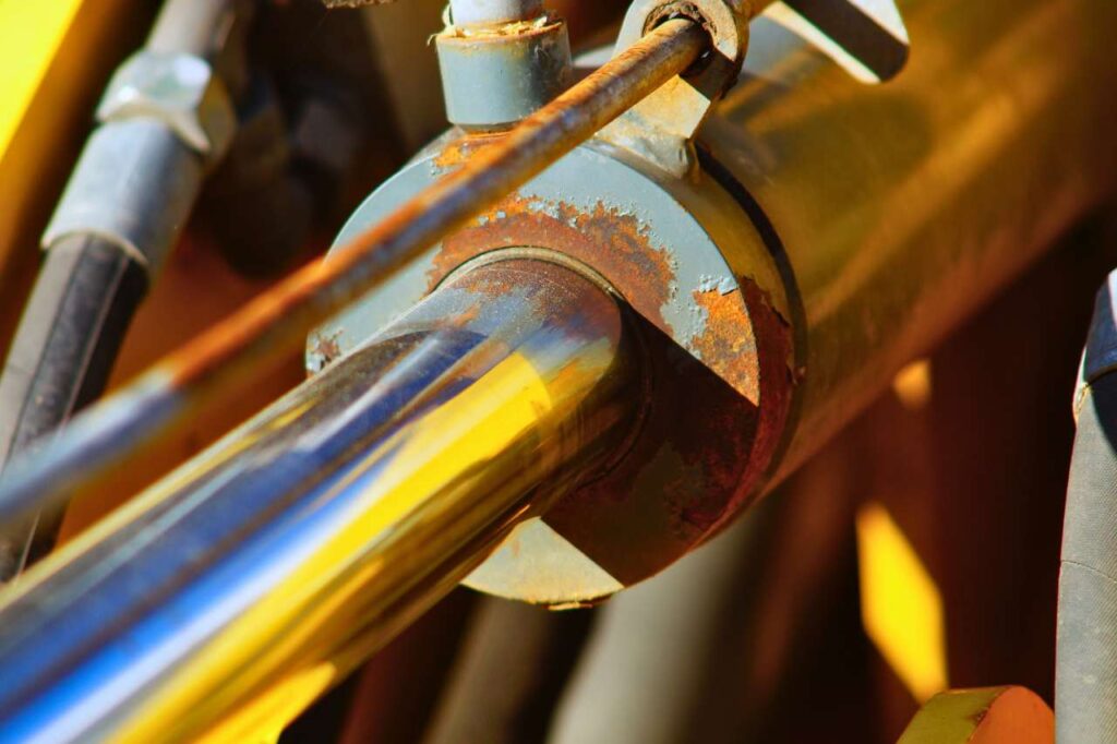 A close-up of a corroded pipe in manufacturing, showing rust.