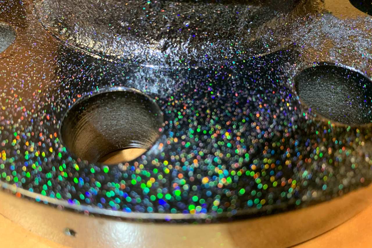 A close-up view at the reflective black powder coat coating on a piece of machinery.