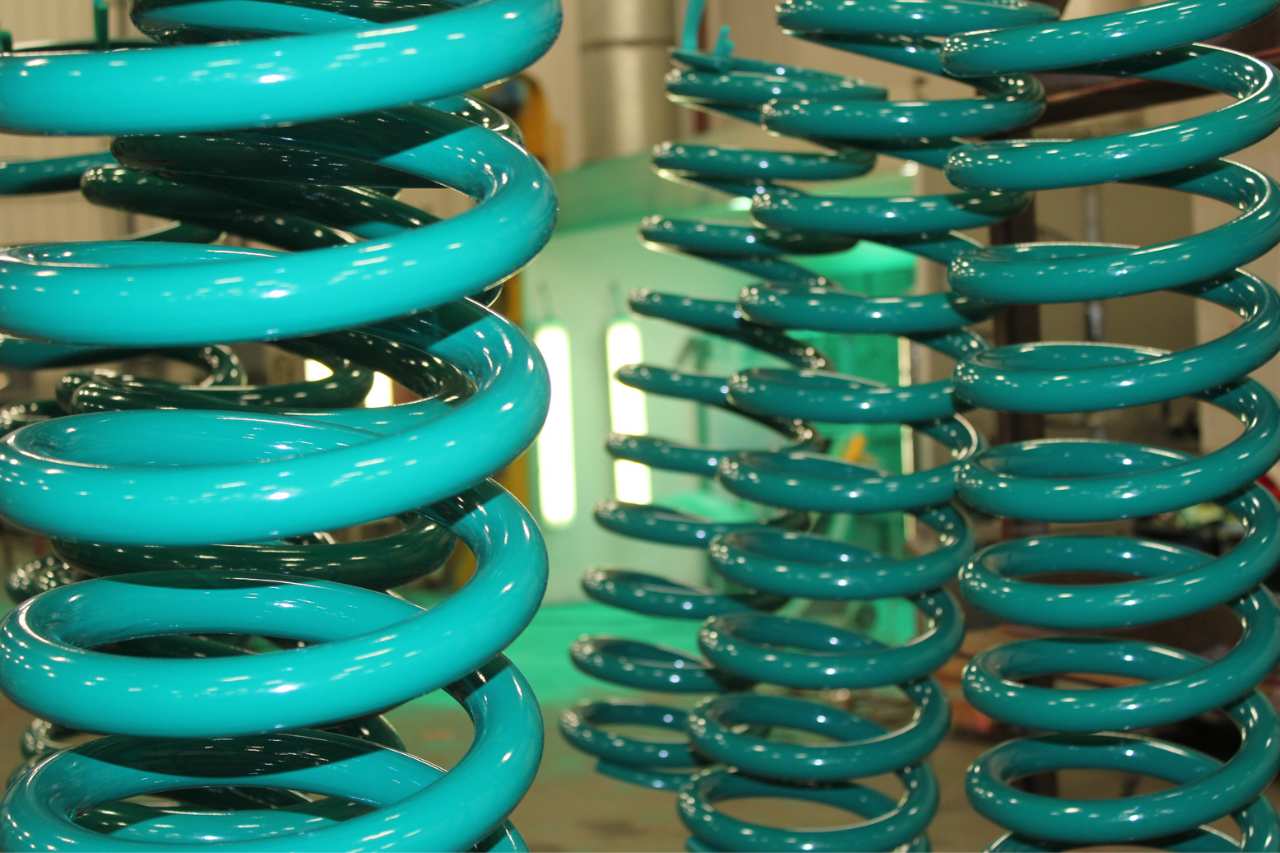 Industrial springs that have been coated in a green protective coating by IPC.